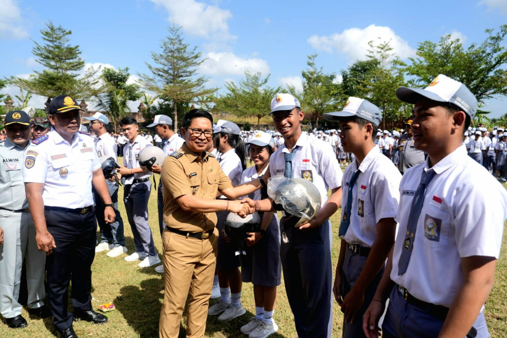 Tanamkan Budaya Tertib Lalu Lintas  Bupati Adi Arnawa Bagi-Bagi Helm di SMAN 2 Abiansemal