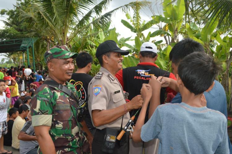 Bhabinkamtibmas dan Babinsa Membantu Anak-Anak Melepaskan Ikan